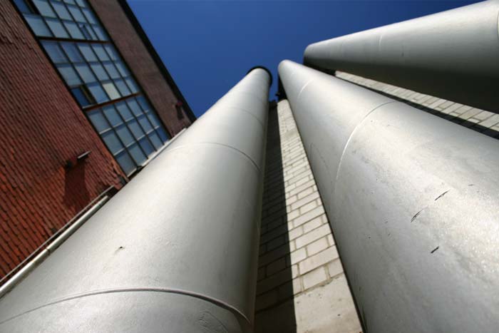 Drei graue Rohre, die an einer Wand gen Himmel f�hren